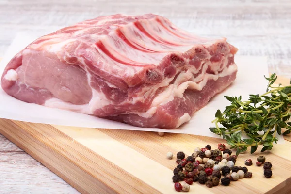 Daging babi mentah, rempah-rempah dan rosemary di papan potong. Siap untuk memasak . — Stok Foto