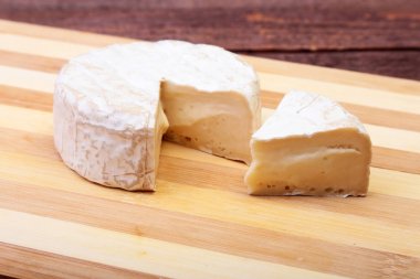 İle beyaz kalıp peynir. Ahşap masa Camembert veya brie tipi. Sağlıklı kahvaltı.