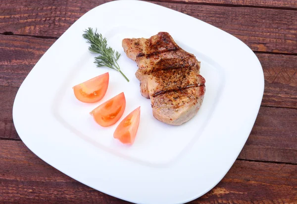 Grilled pork chop with vegetable on plate on wooden board — Stock Photo, Image