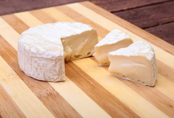 İle beyaz kalıp peynir. Ahşap masa Camembert veya brie tipi. Sağlıklı kahvaltı. — Stok fotoğraf