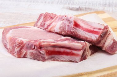 Çiğ domuz pirzolası, kesme tahtası üzerinde baharat. Hazır yemek pişirmek için.