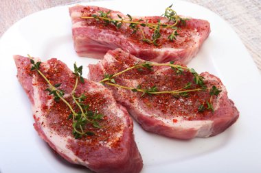 Çiğ domuz eti, baharat ve biberiye kesme tahtası üzerinde. Hazır yemek pişirmek için.