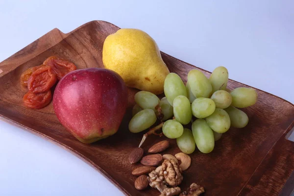 Świeżych owoców na drewno obsługujących taca. Różne firmy apple, gruszki i winogrona. — Zdjęcie stockowe