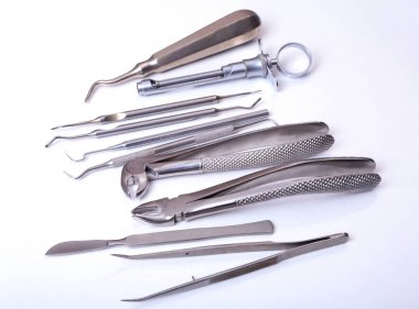 Beyaz arka plan üzerinde izole dişler diş bakımı için metal tıbbi ekipman araç kümesi.