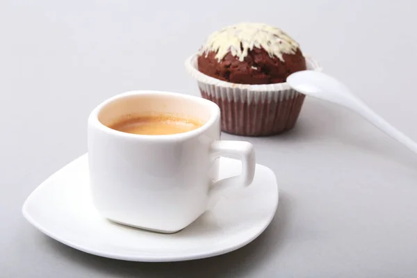 Café expresso clássico em xícara branca com bolo caseiro e chocolate em fundo branco . — Fotografia de Stock