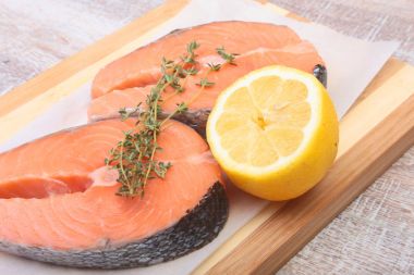 baharatlar ve ahşap kesme tahtası üzerinde limon ile taze Çiğ somon. gezmek için hazır