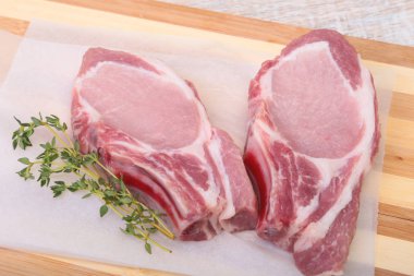 Çiğ domuz eti, baharat ve biberiye kesme tahtası üzerinde. Hazır yemek pişirmek için.