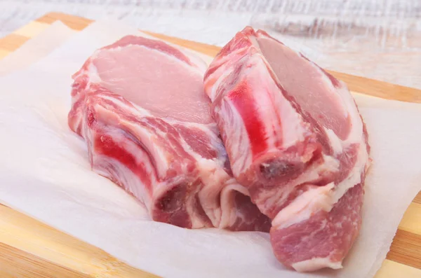 Chuletas de cerdo crudas, especias en tabla de cortar. Listo para cocinar . —  Fotos de Stock