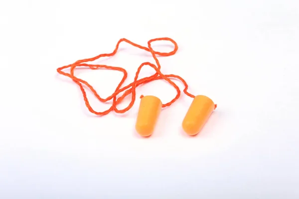 Bouchon d'oreille orange pour le travail. Bouchon d'oreille pour réduire le bruit sur fond blanc  . — Photo