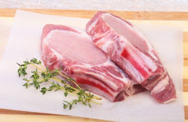 Çiğ domuz eti, baharat ve biberiye kesme tahtası üzerinde. Hazır yemek pişirmek için.