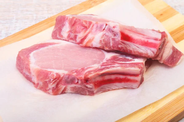 Chuletas de cerdo crudas, especias en tabla de cortar. Listo para cocinar . — Foto de Stock
