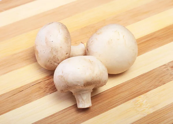 Cogumelos brancos frescos champignon no fundo de madeira. — Fotografia de Stock