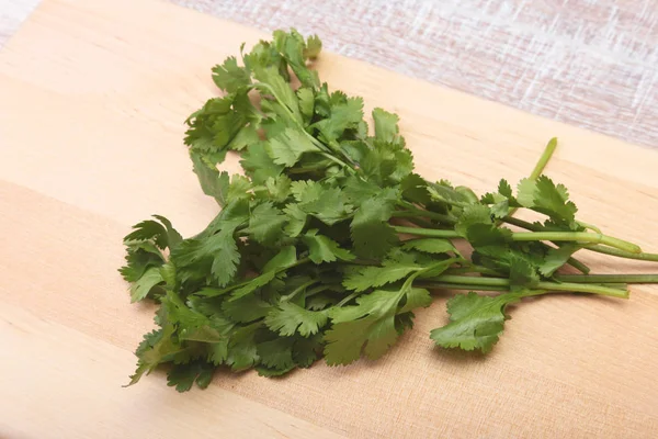 Fresh green cilantro, coriander leaves on wooden table