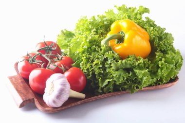 Taze çeşitli sebze çan biber, domates, sarımsak yaprak marul ile. Beyaz arka plan üzerinde izole. Seçici odak.