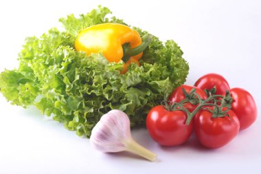 Taze çeşitli sebze çan biber, domates, sarımsak yaprak marul ile. Beyaz arka plan üzerinde izole. Seçici odak.