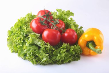 Taze çeşitli sebze çan biber, domates, sarımsak yaprak marul ile. Beyaz arka plan üzerinde izole. Seçici odak.
