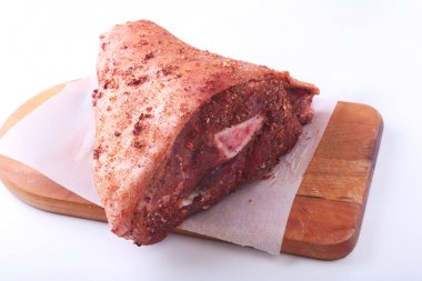 Çiğ domuz knuckle ve baharat bir kesme tahtası üzerinde. Seçici odak. Hazır yemek pişirmek için.