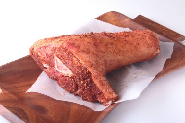 Çiğ domuz knuckle, sarımsak ve baharat bir kesme tahtası üzerinde. Seçici odak. Hazır yemek pişirmek için.