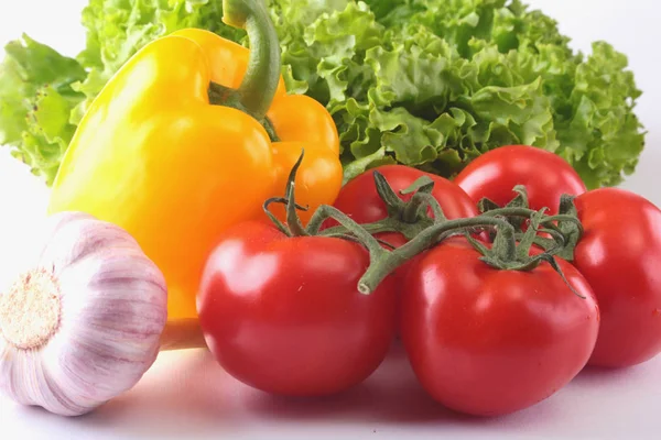 Fresh assorted vegetables bell pepper, tomato, garlic with leaf lettuce. Isolated on white background. Selective focus. — Stock Photo, Image