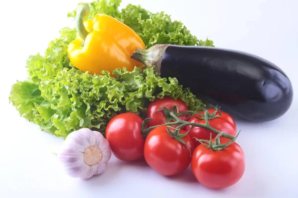 Fresh assorted vegetables, eggplant, bell pepper, tomato, garlic with leaf lettuce. Isolated on white background. Selective focus. — Stock Photo, Image