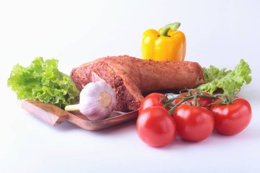 Çiğ domuz knuckle ve sebze, sarımsak, domates, dolmalık biber. baharat ve marul yaprakları bir kesme tahtası üzerinde. Seçici odak. Hazır yemek pişirmek için.