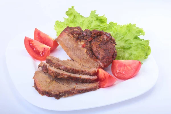Стейк из мяса на гриле с помидорами, салатом и бобами граната на белой тарелке . — стоковое фото