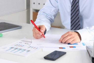 Laptop ile masada oturan ve ofiste germe neşeli genç işadamı