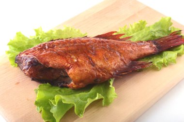 Füme balık ve beyaz arka plan üzerinde izole tahta kesme tahta üzerinde yeşil marul yaprakları limon.