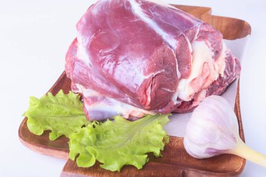 Ham sığır eti shanks, sarımsak ve marul yaprak yukarıdan beyaz arka plan ve kopya alanı izole ahşap masa üzerinde. hazır yemek pişirmek için.