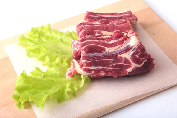 Bords de boeuf cru et feuille de laitue sur un bureau en bois isolé sur fond blanc par le haut et espace de copie. prêt pour la cuisson — Photo