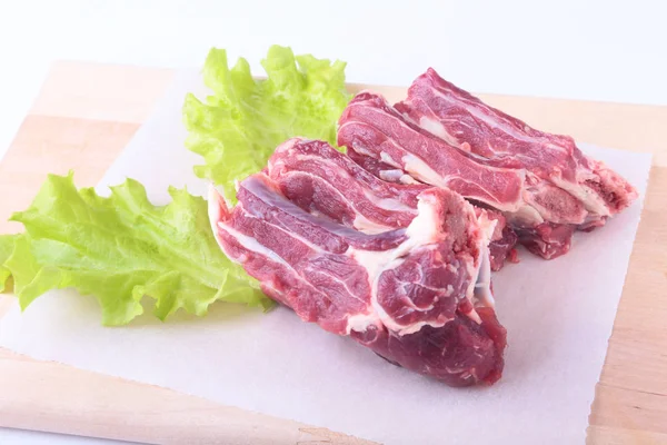 Bords de boeuf cru et feuille de laitue sur un bureau en bois isolé sur fond blanc par le haut et espace de copie. prêt pour la cuisson — Photo