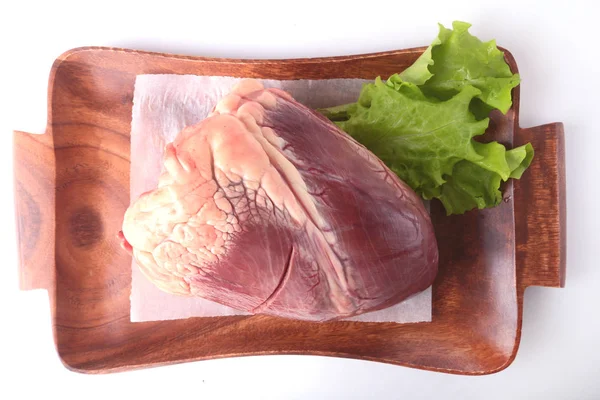 Rohes Rinderherz und Salatblatt auf Holztisch isoliert auf weißem Hintergrund von oben und kopieren Raum. Fertig zum Kochen. — Stockfoto