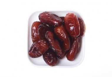 Beyaz arka plan üzerinde izole kase lezzetli kurutulmuş organik tarihleri.