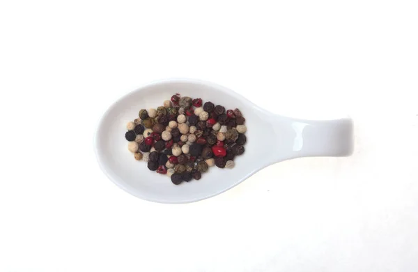 Mezcla de granos de pimienta negra, blanca y roja en un tazón aislado sobre fondo blanco . — Foto de Stock