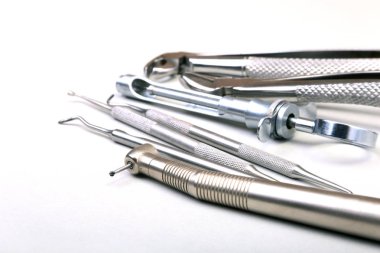 Beyaz arka plan üzerinde diş diş bakımı için metal tıbbi malzeme araçlar kümesi. Seçici odak.