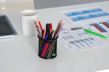 Not defterleri, kalem, kahve fincanı ve diğer öğeleri ile beyaz masaüstü closeup. Seçici odak.