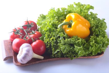 Taze çeşitli sebze çan biber, domates, sarımsak yaprak marul ile. Beyaz arka plan üzerinde izole. Seçici odak.