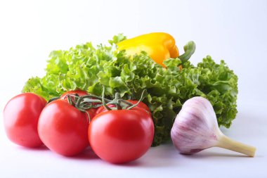 Taze çeşitli sebze çan biber, domates, sarımsak yaprak marul ile. Beyaz arka plan üzerinde izole. Seçici odak.