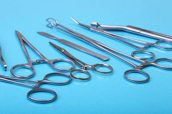 Close Up chirurgische instrumenten en hulpmiddelen op blauwe spiegel achtergrond. Selectieve aandacht. — Stockfoto