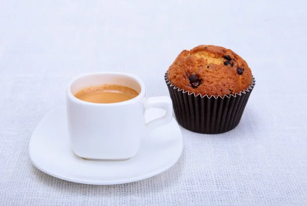 Frische hausgemachte Muffins, Kuchen und weiße Tasse Cappuccino auf weißem Hintergrund. — Stockfoto