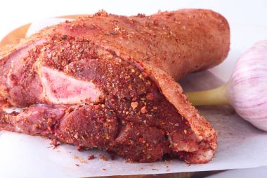 Çiğ domuz knuckle, sarımsak ve baharat bir kesme tahtası üzerinde. Seçici odak. Hazır yemek pişirmek için.