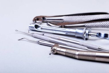 Beyaz arka plan üzerinde diş diş bakımı için metal tıbbi malzeme araçlar kümesi. Seçici odak.