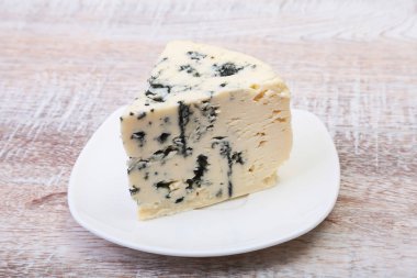 Ahşap masa üzerinde lezzetli mavi peynir ile plaka