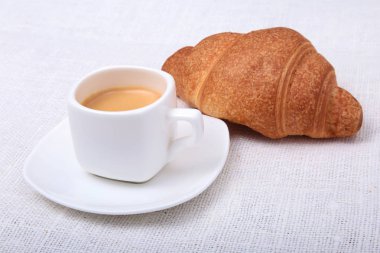 Gevrek ev yapımı taze kruvasanlar ve fincan kahve espresso bir beyaz arka plan, sabah kahvaltı, seçici odak