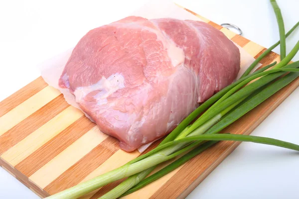 Steaks de porc avec de la graisse. La viande est sur une planche de bois avec des épices comme le poivre et l'oignon vert de printemps. Prêt pour la cuisine. Concentration sélective . — Photo
