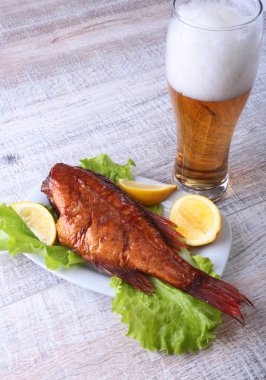 Beyaz arka plan üzerinde izole bira ile balık ve limon yeşil marul yaprakları ahşap kesme tahtası ve cam üzerinde füme.