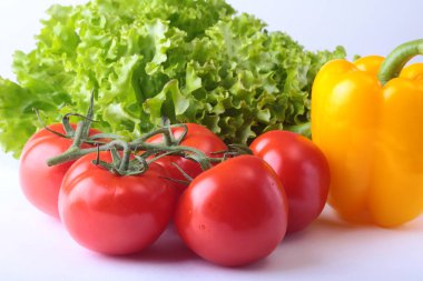 Taze çeşitli sebze çan biber, domates, sarımsak yaprak marul ile. Beyaz arka plan üzerinde izole. Seçici odak.