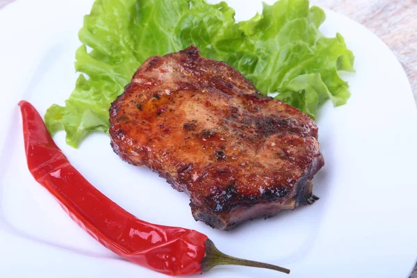 Steak z grilovaného masa a chilli s rajčaty, salátových listů na bílé plotně. — Stock fotografie