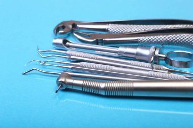 Mavi arka plan üzerinde diş diş bakımı için metal tıbbi malzeme araçlar kümesi. Seçici odak.