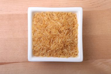 Pirinç bir kase ahşap arka plan üzerinde. hazır yemek pişirmek için.